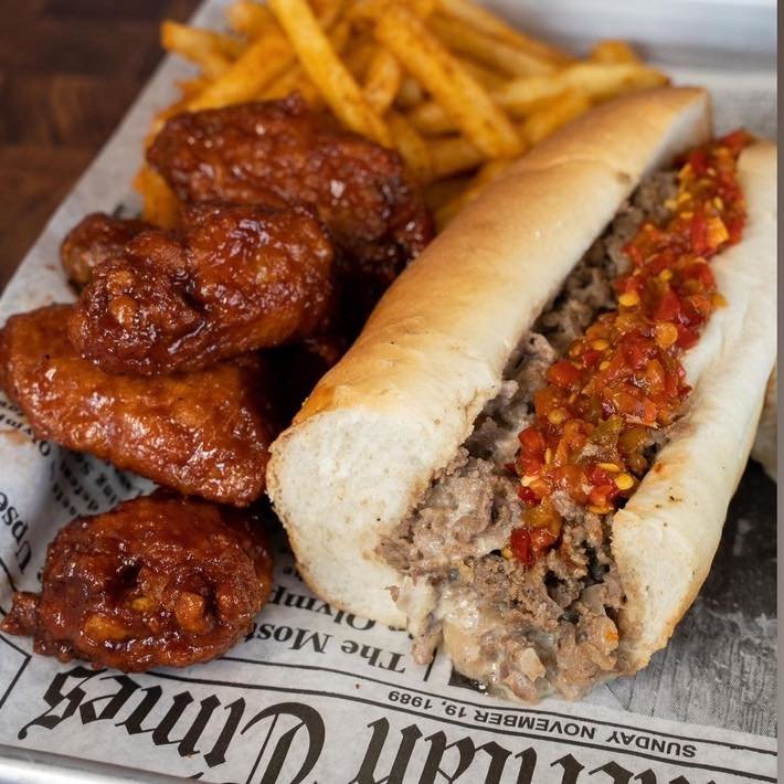 A hoagie with a side of wings and fries from Lefty's Cheesesteaks.