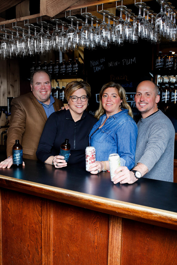 Dede Beck (second from left) co-owns Uncle John’s Cider Mill with her husband, Mike Beck, and brother-in-law, John Heystek.