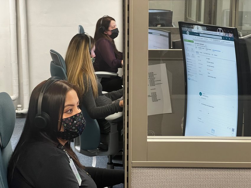 Six newly hired customer service agents take 311 calls in the basement of the South Washington Office Complex.